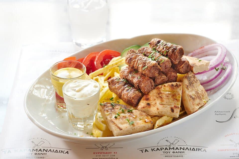 Aivali meatballs with pita bread, salad, potatoes, yoghurt and mustard sauce. A main course at Karamanlidika Food-Artistry restaurant, on 119 Ermou str., in Athens.